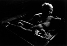A mother bathes her child, who severely disabled due to mercury poisoning